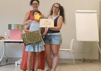 Bambina accolta in comunità ritratta durante la consegna attestati del progetto "Come api mellifere" - Associazione CAF